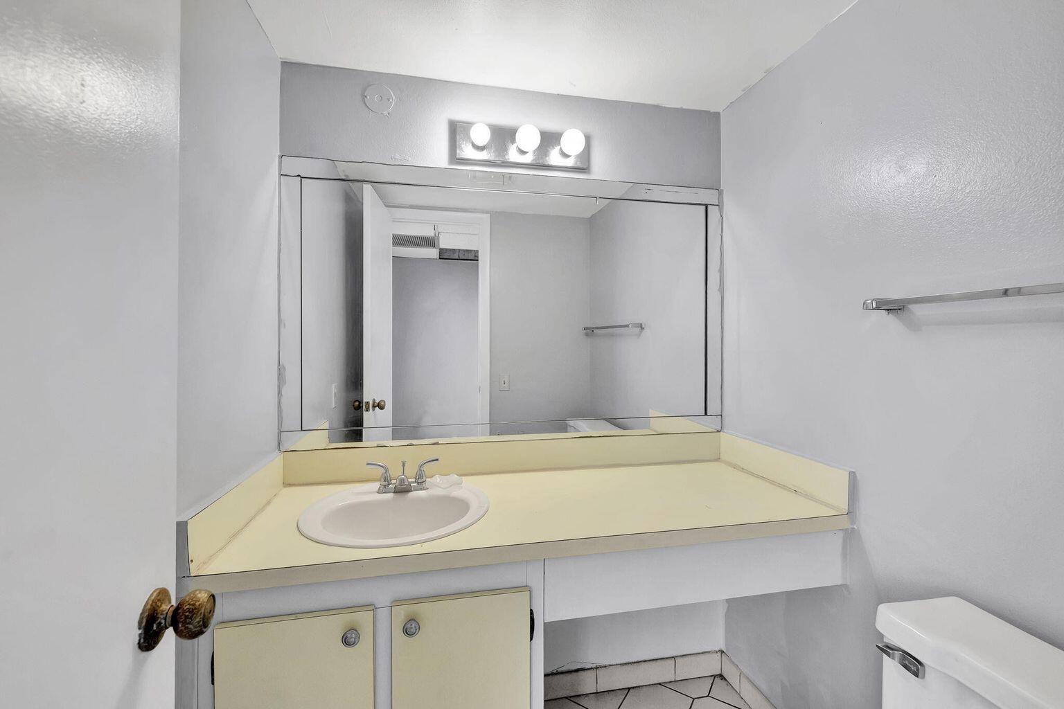 9300 Lime Bay Boulevard, Unit 302 Tamarac, FL 33321 - Photo 8 of 15 a bathroom with a sink and a mirror