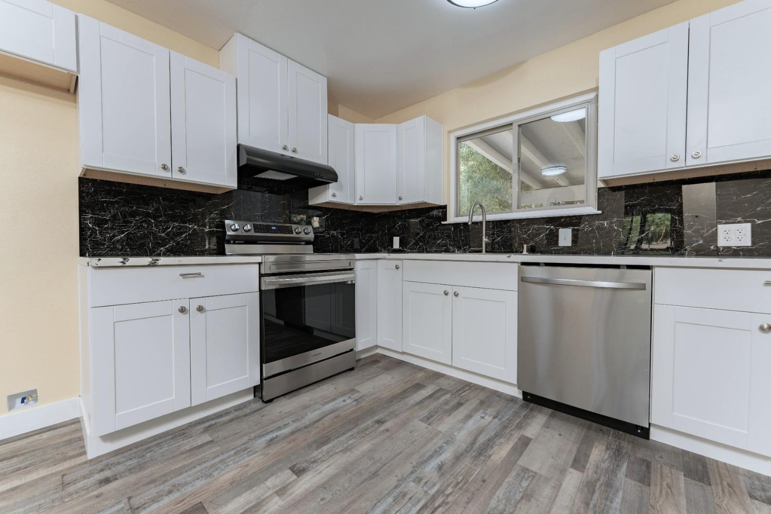 47517 Road 200 O'Neals, CA 93645 - Photo 11 of 54 a kitchen with granite countertop wooden cabinets and white appliances