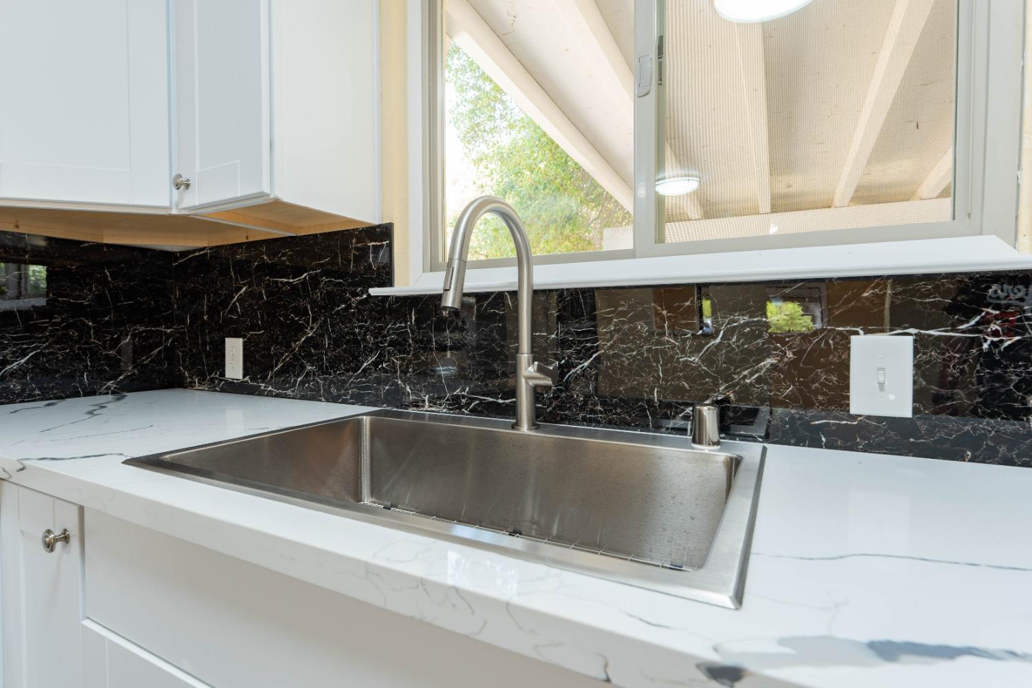 47517 Road 200 O'Neals, CA 93645 - Photo 13 of 54 a view of a kitchen counter top a sink and dishwasher with a black white stove