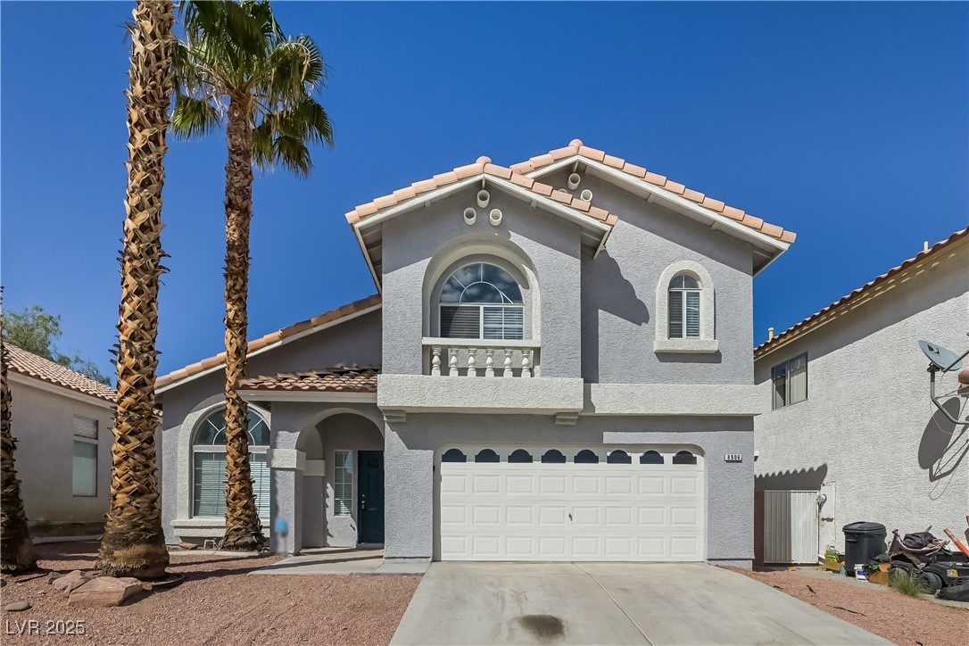 8906 Chapman Point Las Vegas, NV 89129 - Photo 1 of 13 Mediterranean / spanish-style house with driveway, stucco siding, a garage, a tiled roof, and a balcony