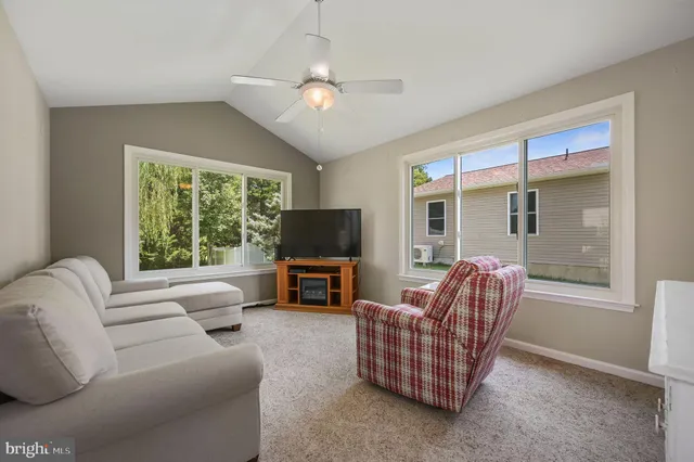 a living room with furniture a flat screen tv and a large window