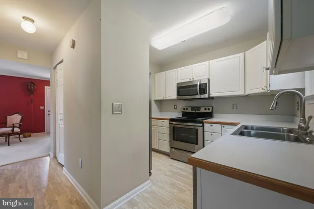 a kitchen with a sink and steel appliances
