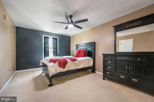 a spacious bedroom with a bed and a dresser