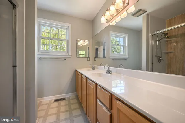 a bathroom with a double vanity sink window and a mirror