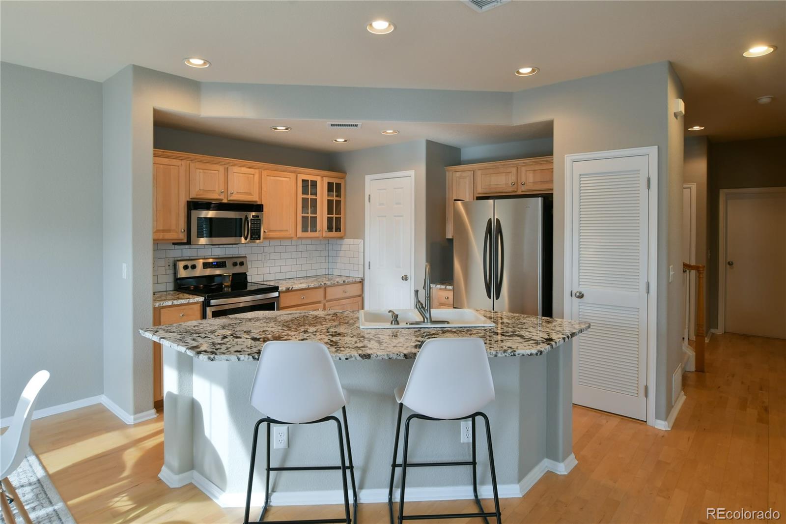 156 Whitehaven Circle Highlands Ranch, CO 80129 - Photo 12 of 30 a kitchen with stainless steel appliances granite countertop a stove a sink a refrigerator and a refrigerator