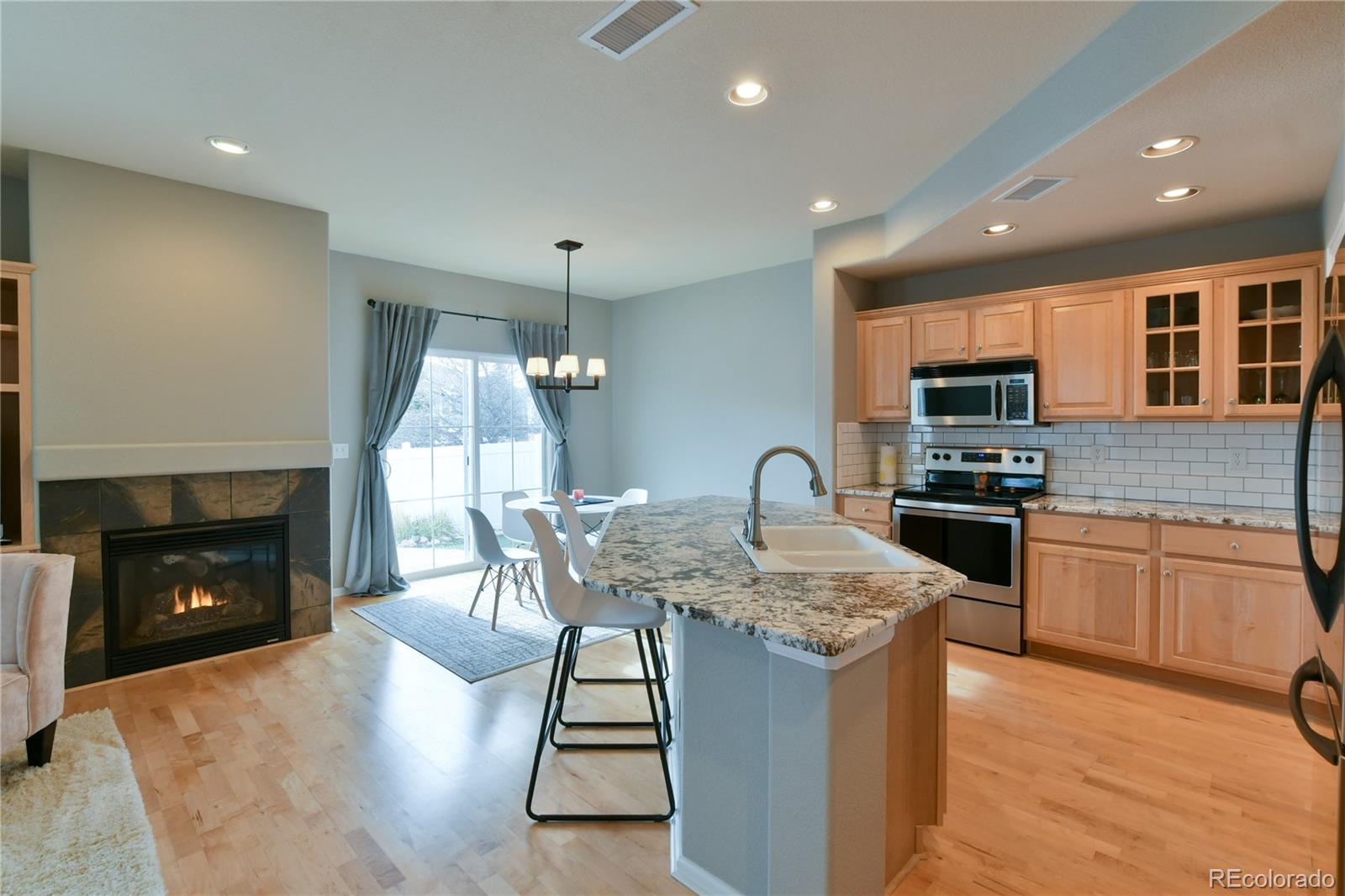 156 Whitehaven Circle Highlands Ranch, CO 80129 - Photo 13 of 30 a kitchen with granite countertop kitchen island stainless steel appliances a stove sink microwave and cabinets