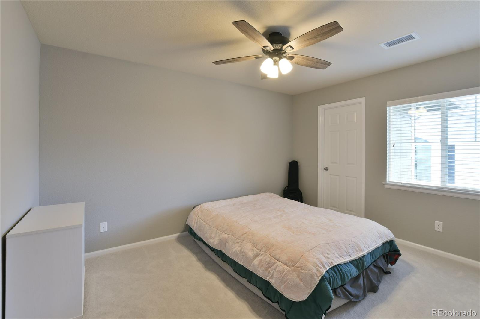 156 Whitehaven Circle Highlands Ranch, CO 80129 - Photo 23 of 30 a bedroom with a bed and a chandelier