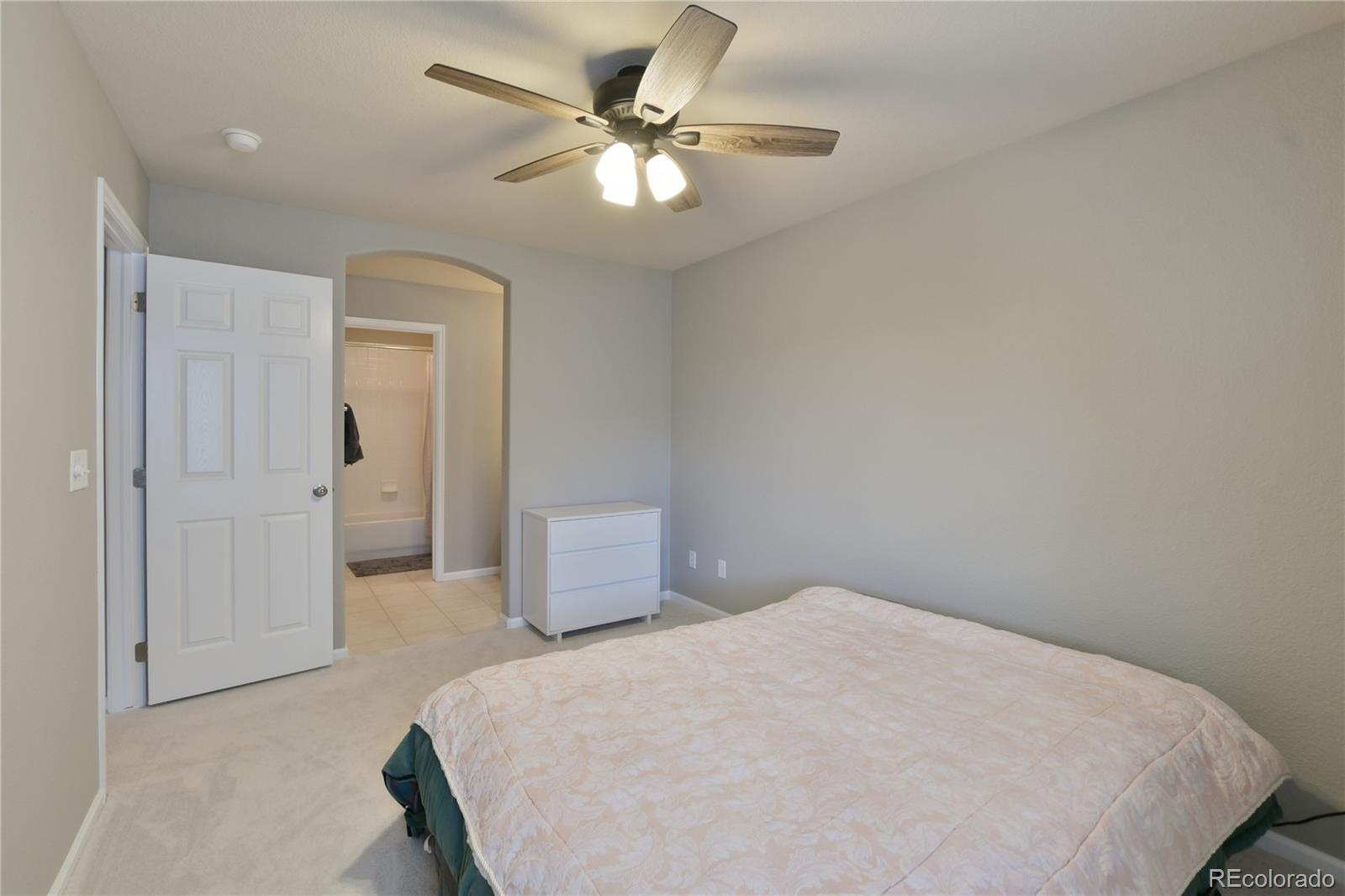 156 Whitehaven Circle Highlands Ranch, CO 80129 - Photo 24 of 30 a bedroom with a bed and a chandelier