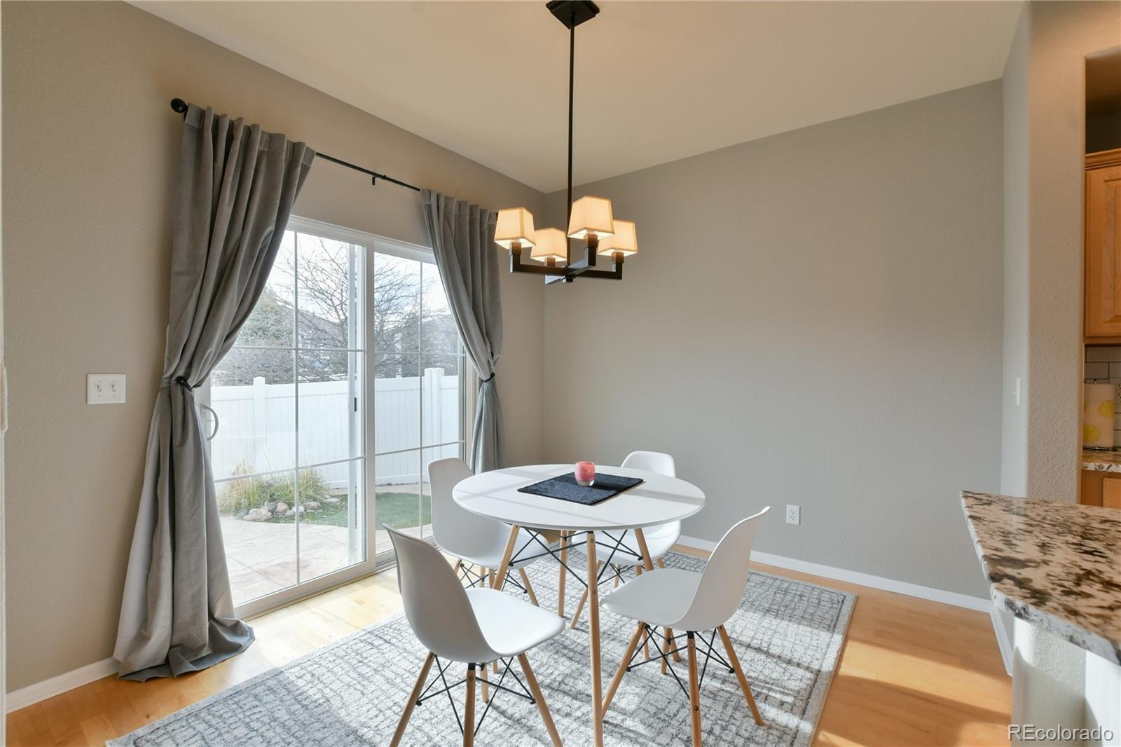 156 Whitehaven Circle Highlands Ranch, CO 80129 - Photo 6 of 30 a dining room with furniture a chandelier and wooden floor