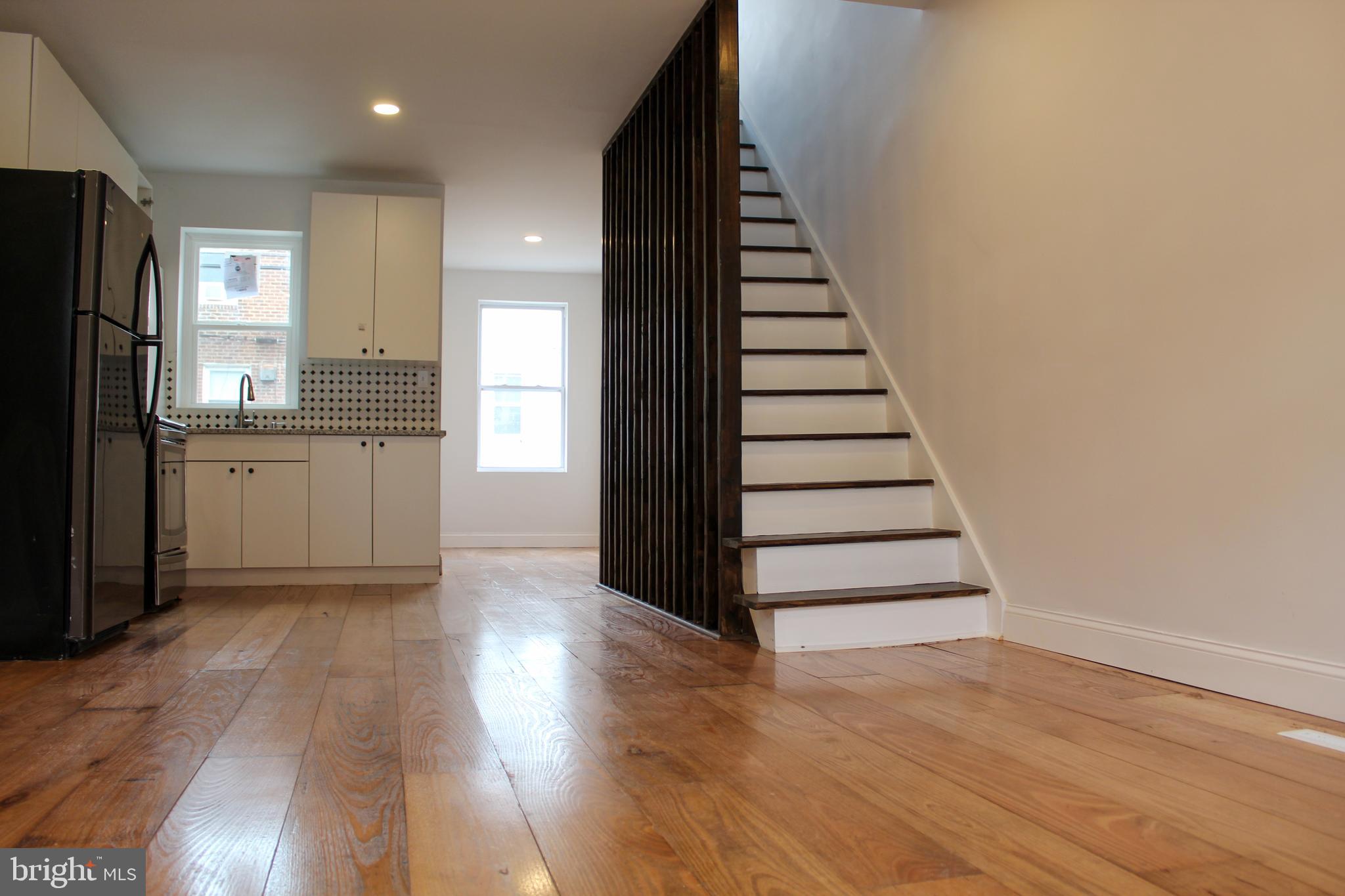2079 Anchor Street Philadelphia, PA 19124 - Photo 5 of 26 a view of a kitchen with wooden floor electronic appliances and stairs