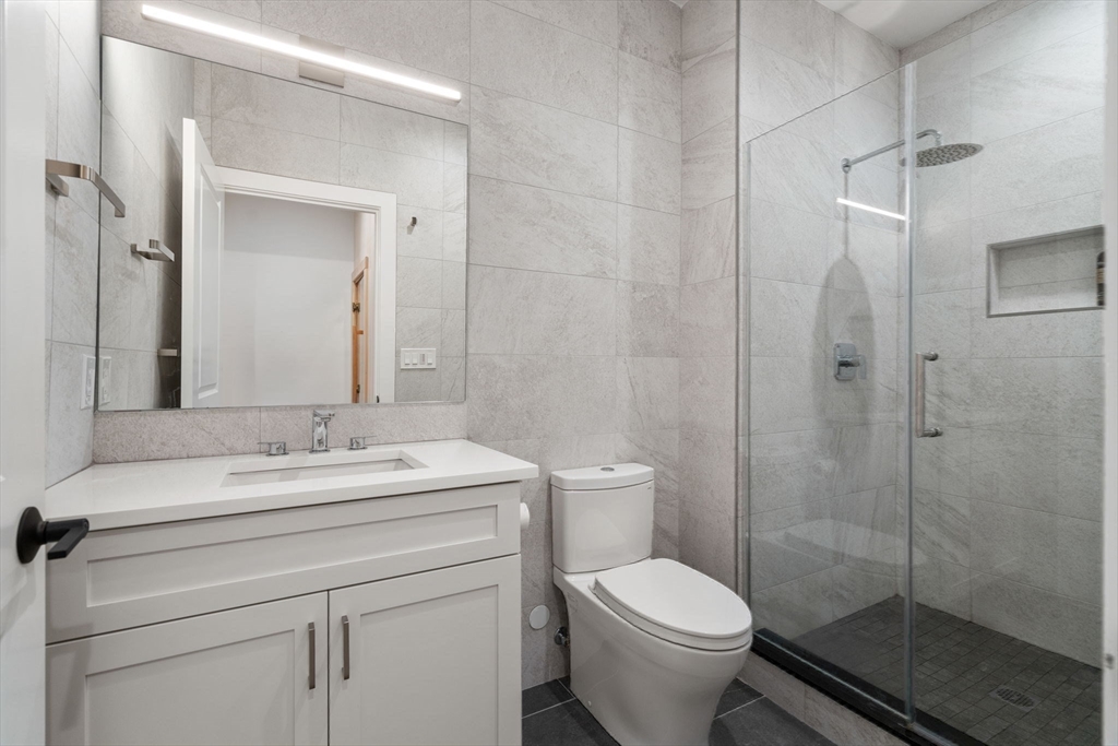 39 Donna Road Needham, MA 02494 - Photo 38 of 42 a bathroom with a granite countertop toilet sink and shower