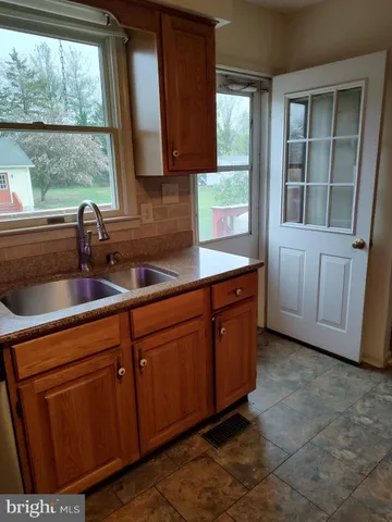 a kitchen with stainless steel appliances granite countertop a sink a stove and a window