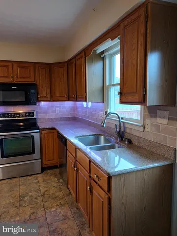 a kitchen with granite countertop a sink and a stove