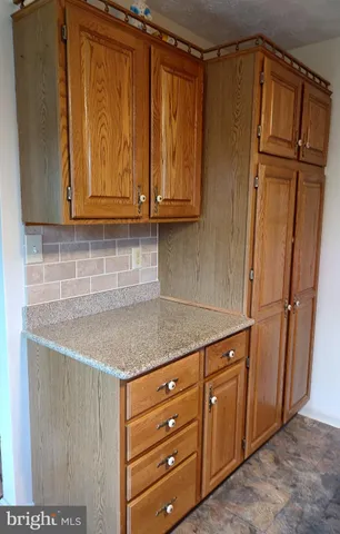 a kitchen with stainless steel appliances granite countertop a refrigerator and cabinets
