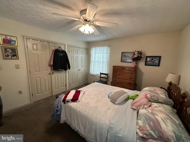 a bedroom with a bed and a flat tv screen on dresser