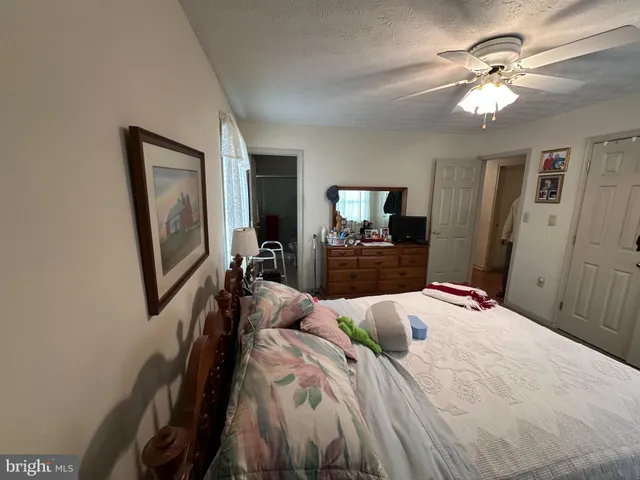 a bedroom with a bed chandelier and a mirror