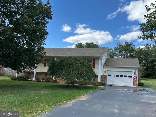 a front view of a house with a garden and trees