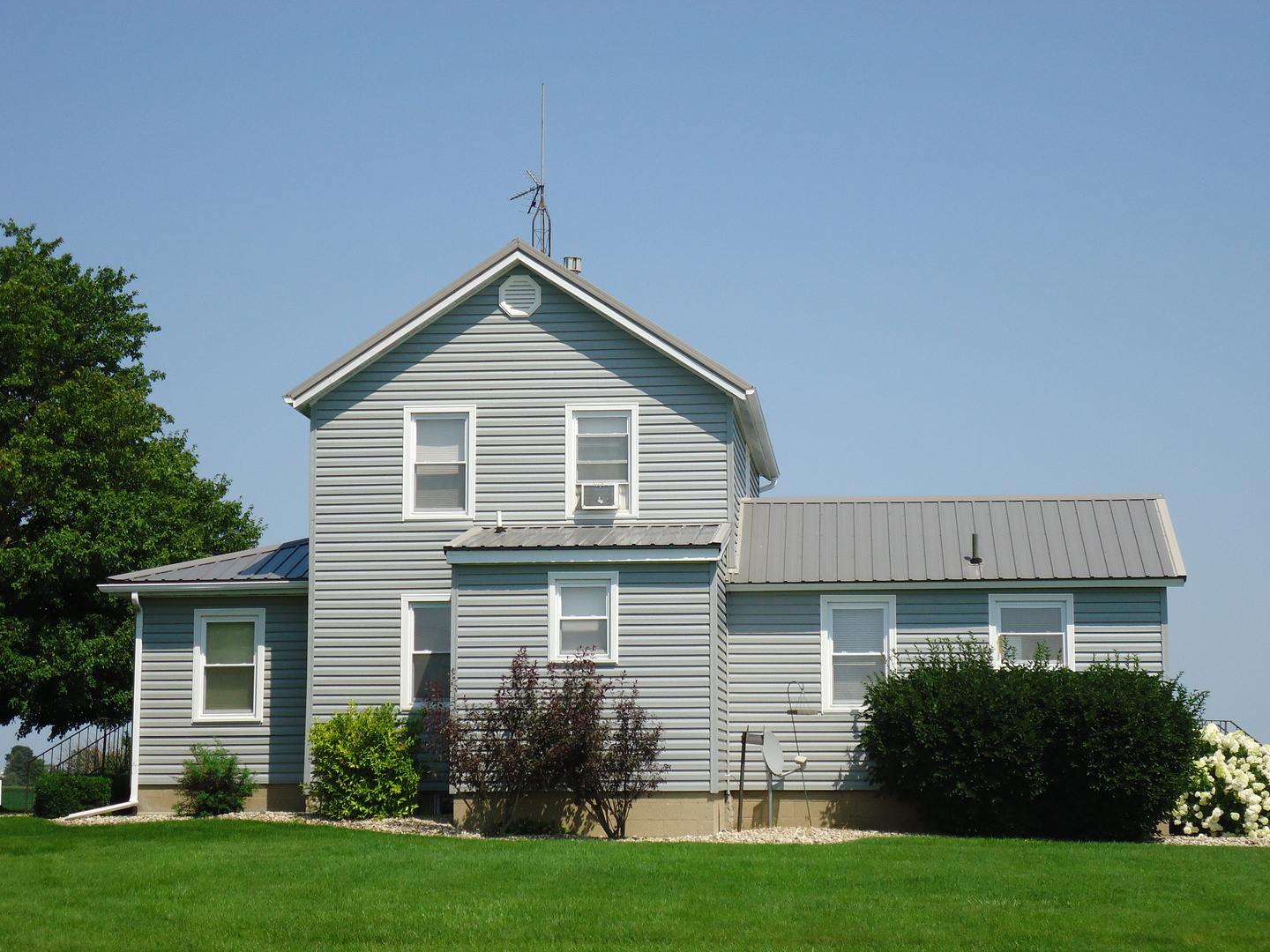a front of a house with a yard and potted plants