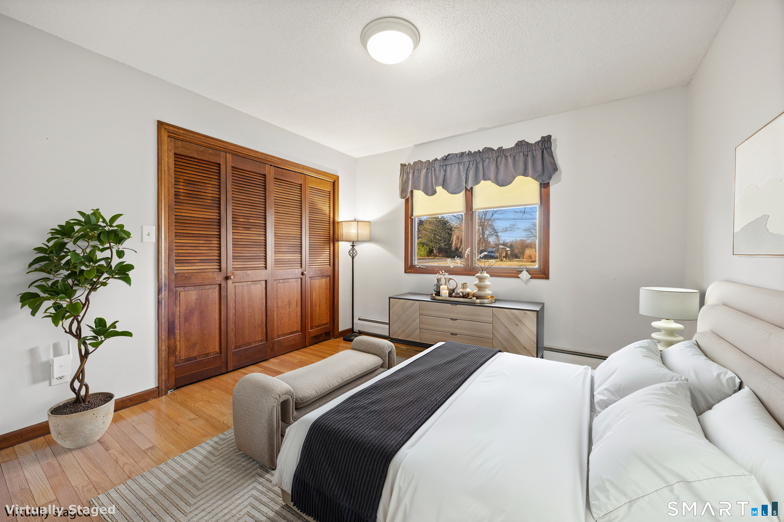 622 Lakeside Boulevard West Waterbury, CT 06708 - Photo 18 of 40 a bedroom with a bed and a potted plant