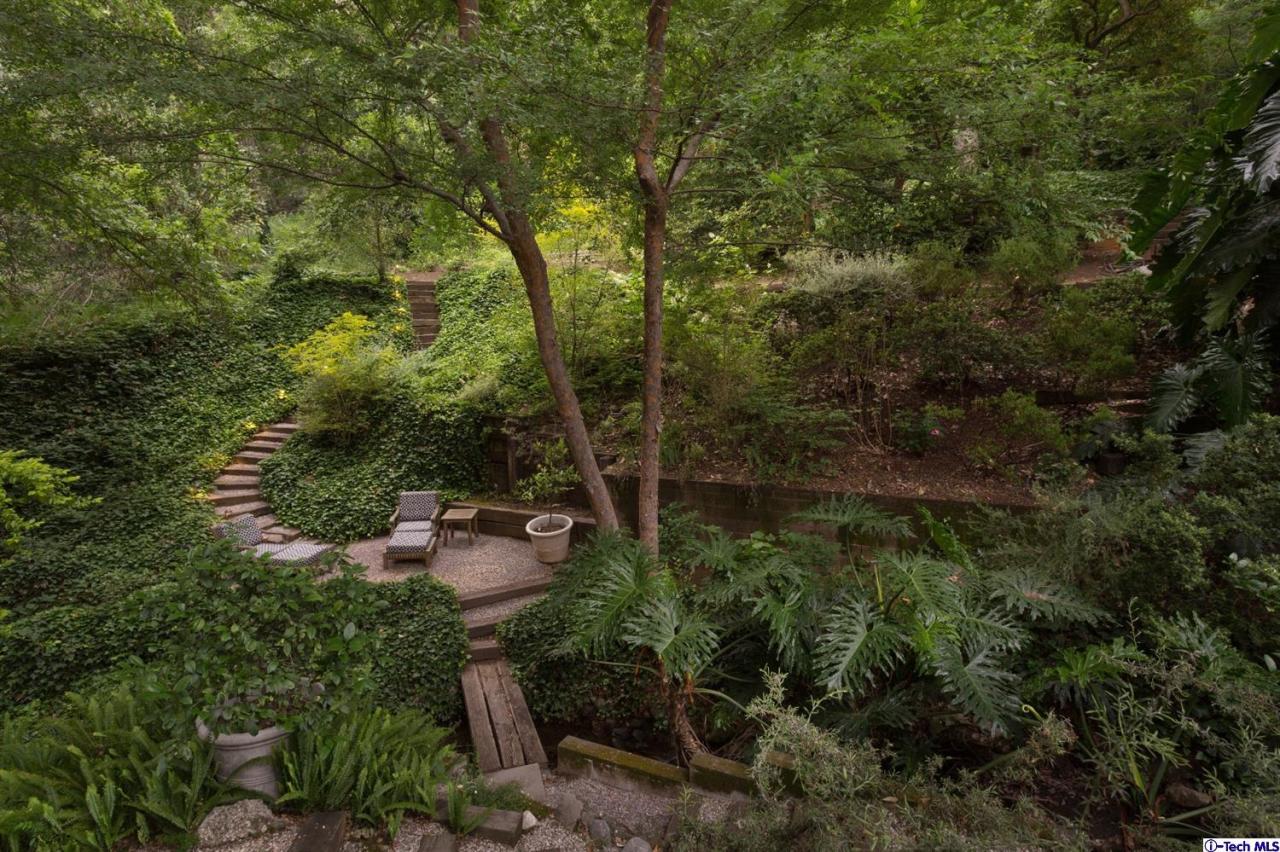 885 Laguna Road Pasadena, CA 91105 - Photo 28 of 33 a backyard of a house with lots of green space and trees