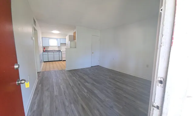 a view of empty room with wooden floor