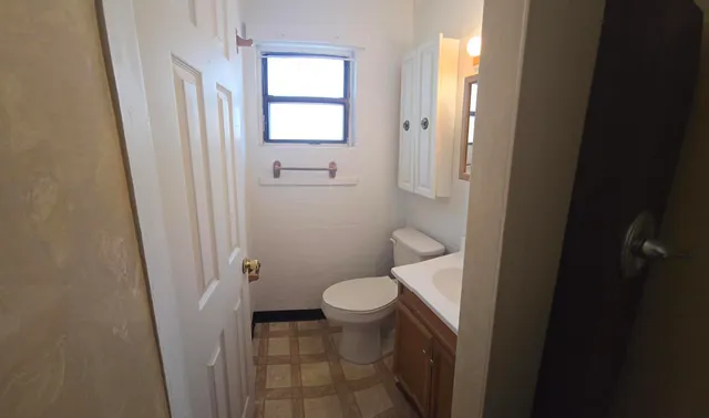 a bathroom with a toilet sink and a mirror