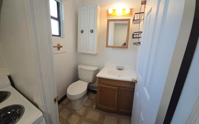 a bathroom with a toilet sink and mirror