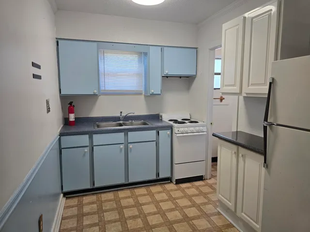a kitchen with a refrigerator sink and cabinets