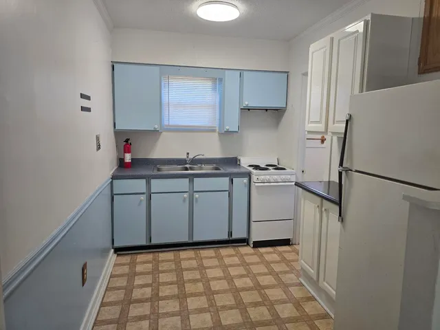 a kitchen with a stove a refrigerator and a sink