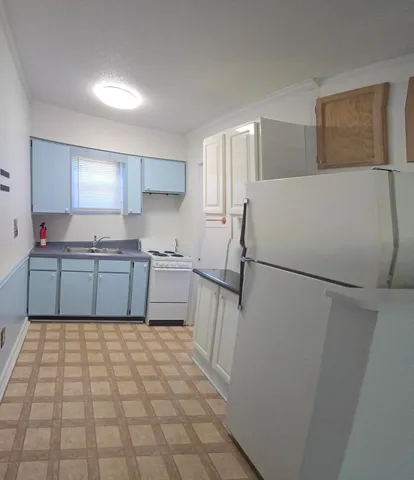 a kitchen with a refrigerator a sink and a stove top oven