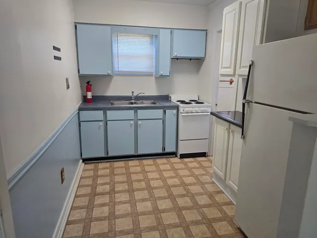 a kitchen with a refrigerator and a stove