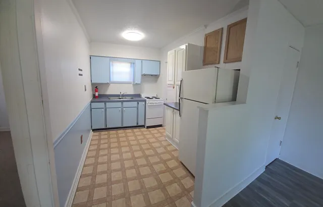 a kitchen with a refrigerator and a stove top oven