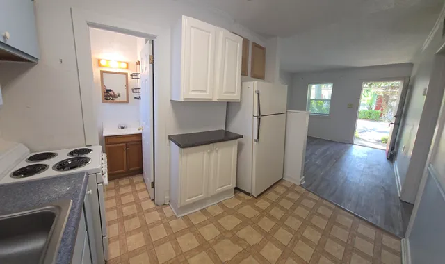 a kitchen with a refrigerator sink and cabinets