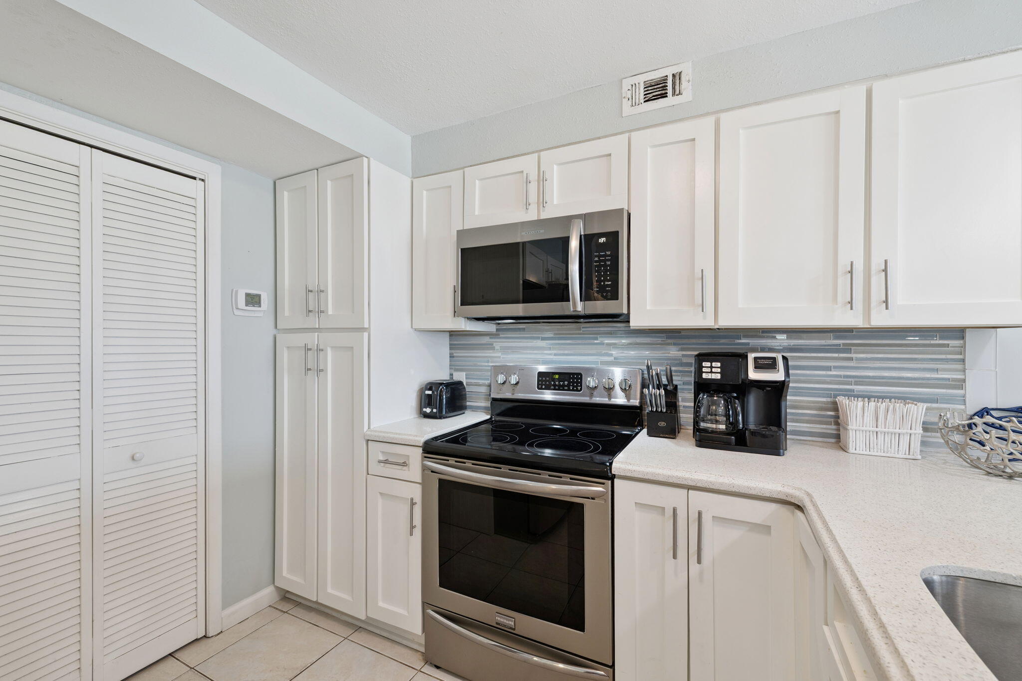 23223 Front Beach Road, Unit C3201 Panama City Beach, FL 32413 - Photo 14 of 45 a kitchen with stainless steel appliances granite countertop white cabinets and a stove