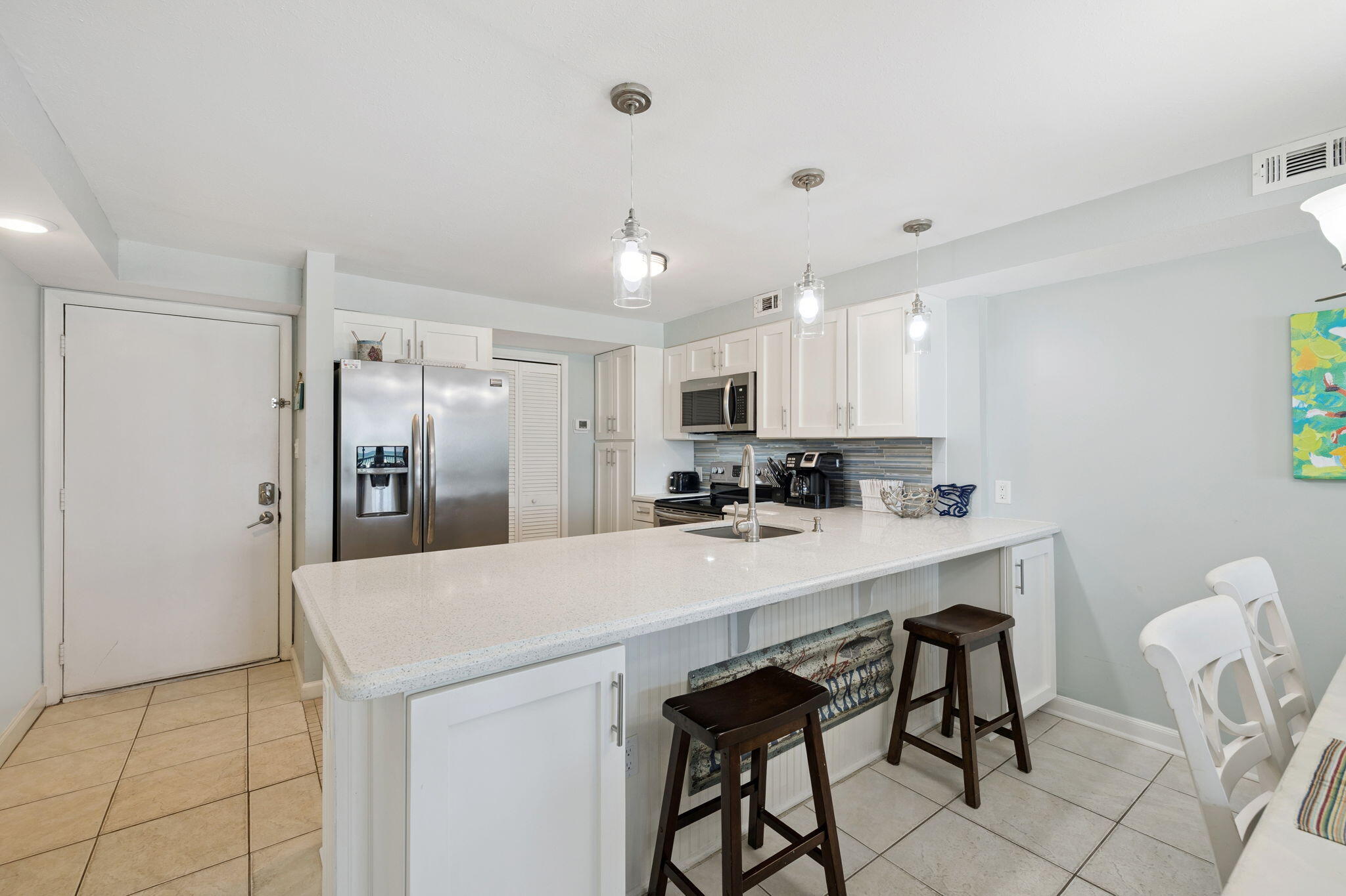 23223 Front Beach Road, Unit C3201 Panama City Beach, FL 32413 - Photo 8 of 45 a kitchen with stainless steel appliances a refrigerator and a table