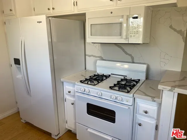 a stove top oven sitting inside of a kitchen
