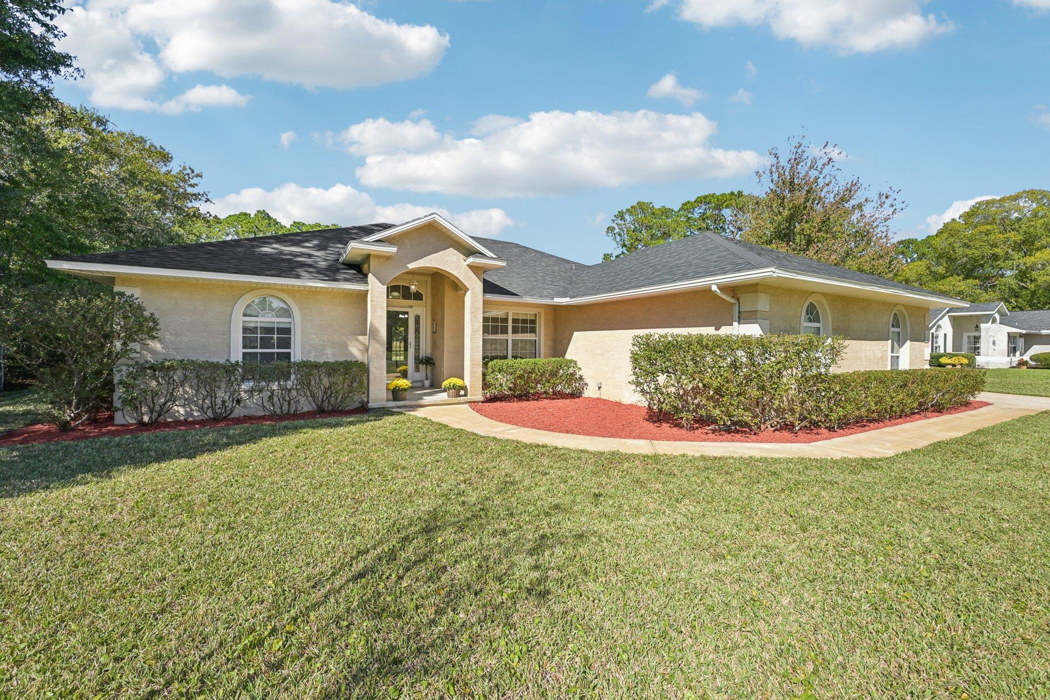 Ranch-style house featuring a front lawn, roof with shingles, and stucco siding