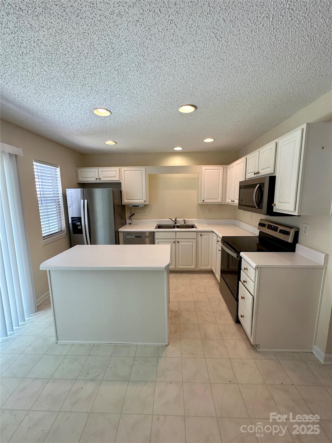 8348 Rudolph Road Charlotte, NC 28216 - Photo 14 of 14 a large kitchen with stainless steel appliances a stove a sink a microwave and a refrigerator