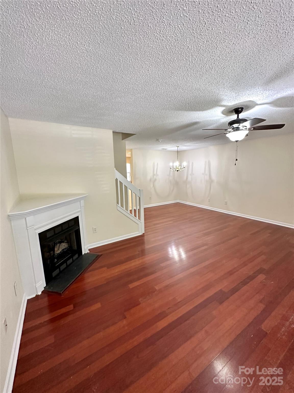 8348 Rudolph Road Charlotte, NC 28216 - Photo 3 of 14 a view of an empty room with wooden floor fireplace and a window