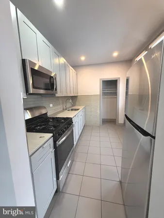 a kitchen with stainless steel appliances granite countertop a refrigerator a stove a sink and a microwave