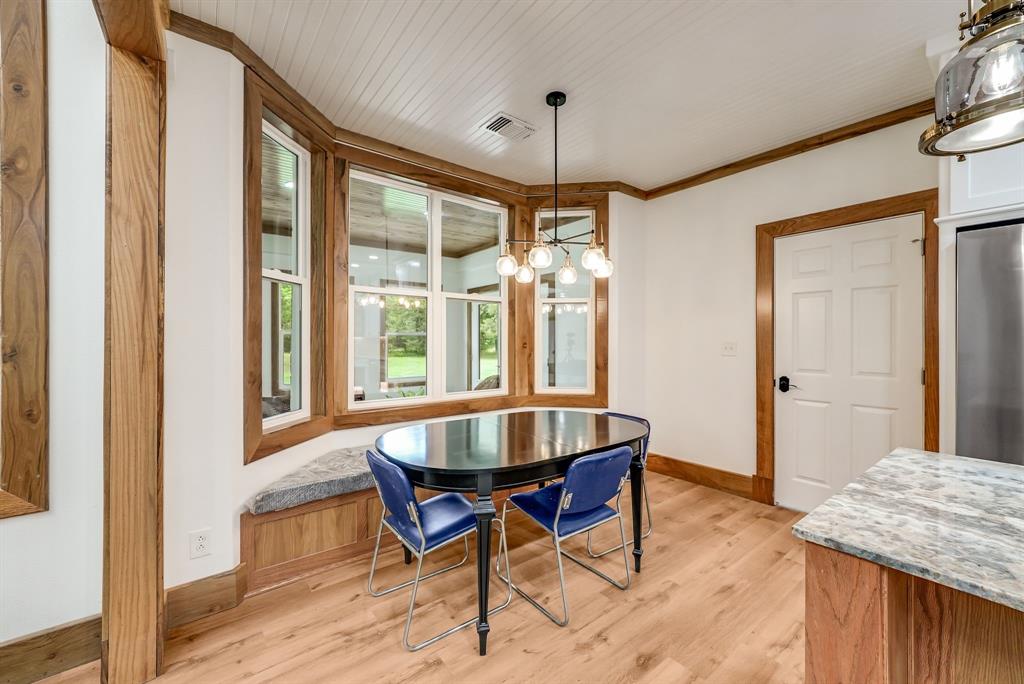 1037 Harrison Road Denison, TX 75021 - Photo 17 of 39 Bay window with integrated window seat, wood-finish flooring, white paneled ceilings, natural wood trim, and a contemporary chandelier