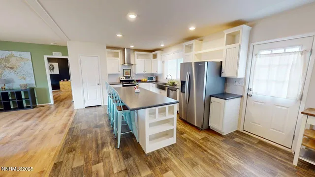a kitchen with stainless steel appliances a refrigerator and wooden floor