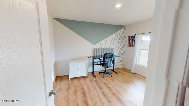 a view of a workspace with furniture and a window