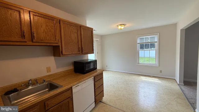 a view of a kitchen with wooden floor and cabinets