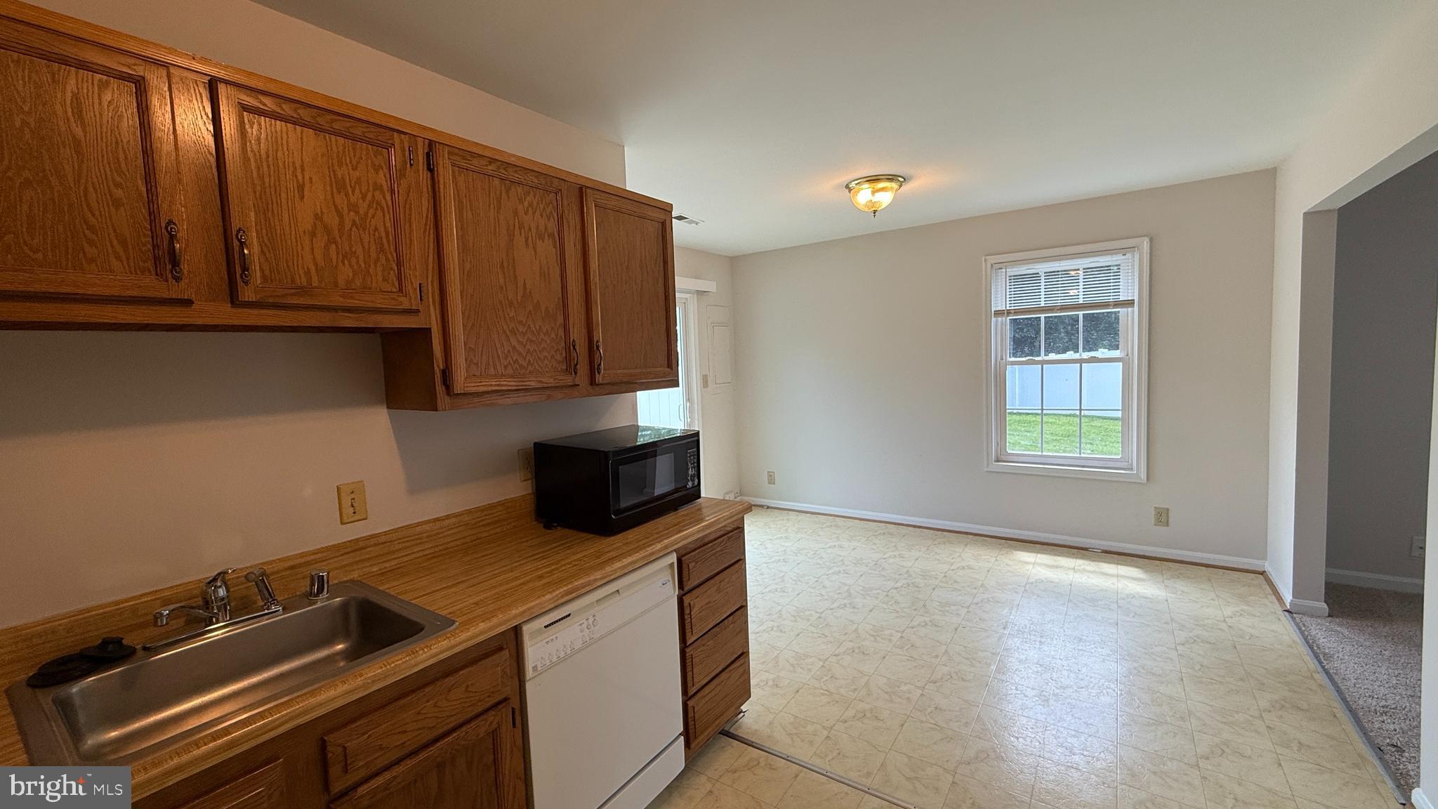 200 Surry Lane, Unit 118 Stafford, VA 22556 - Photo 3 of 13 a view of a kitchen with wooden floor and cabinets