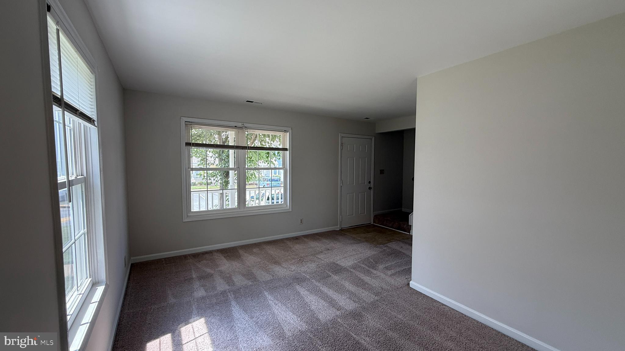 200 Surry Lane, Unit 118 Stafford, VA 22556 - Photo 7 of 13 a view of an empty room with wooden floor and a window