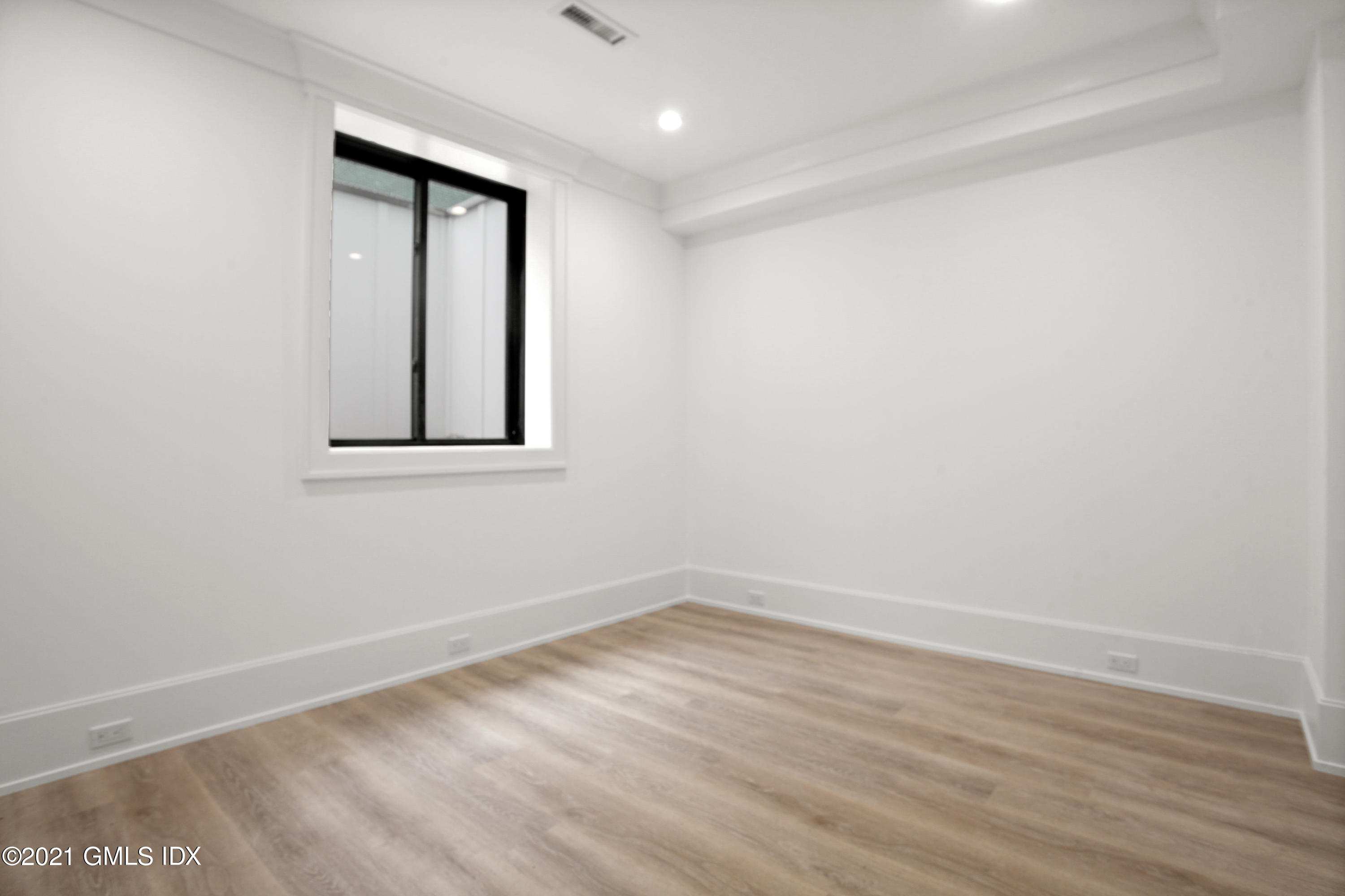 12 Dialstone Lane Riverside, CT 06878 - Photo 54 of 66 an empty room with wooden floor and windows