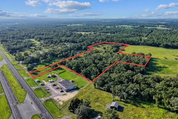 an aerial view of residential houses with outdoor space and trees