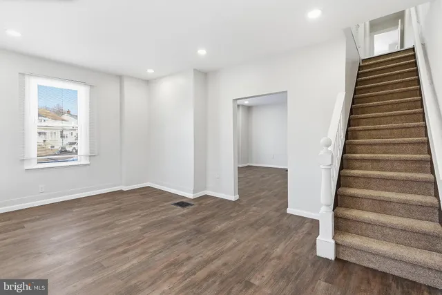 an empty room with wooden floor and a window