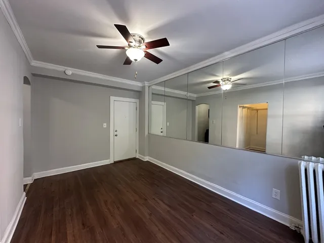a view of an empty room with wooden floor